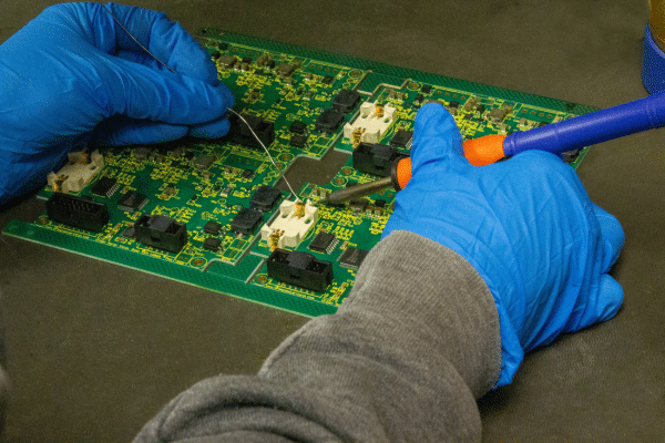 Rainhouse PCB assembly technician inspecting board